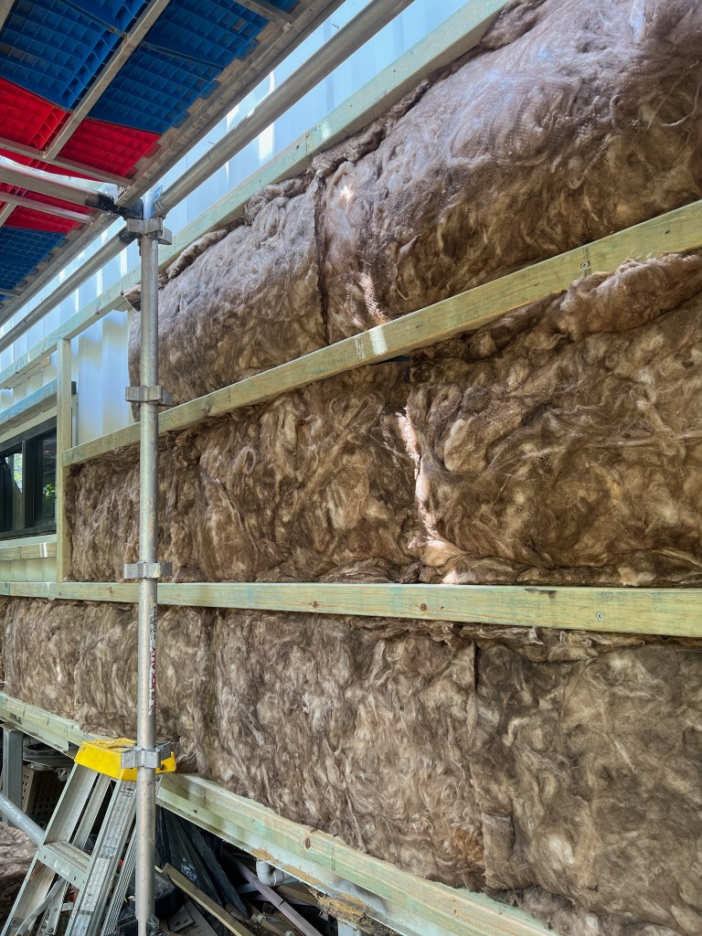 Container house wall with insulation batts